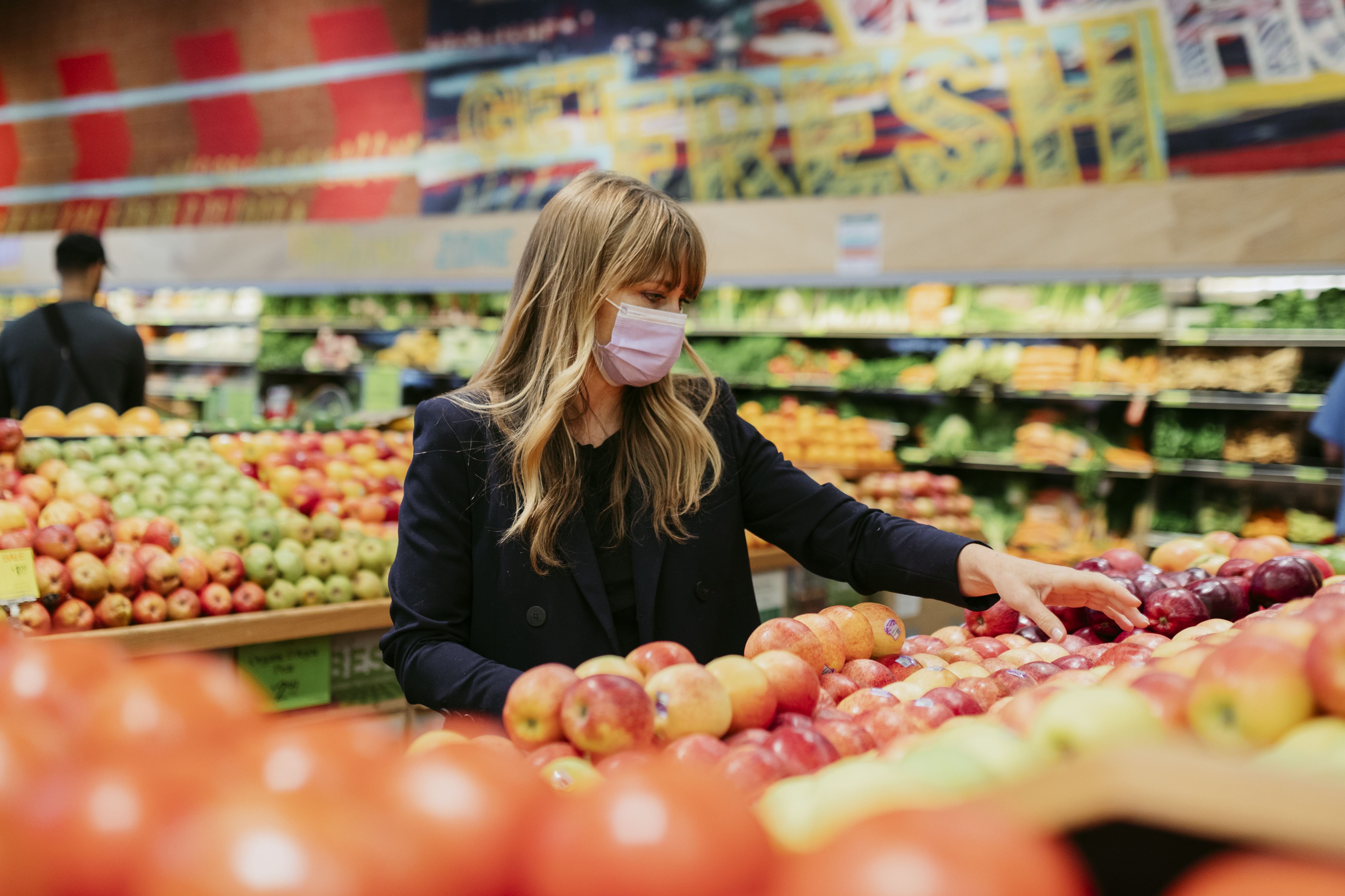 Woman in a face mask while shopping in a supermarket during coronavirus quarantine