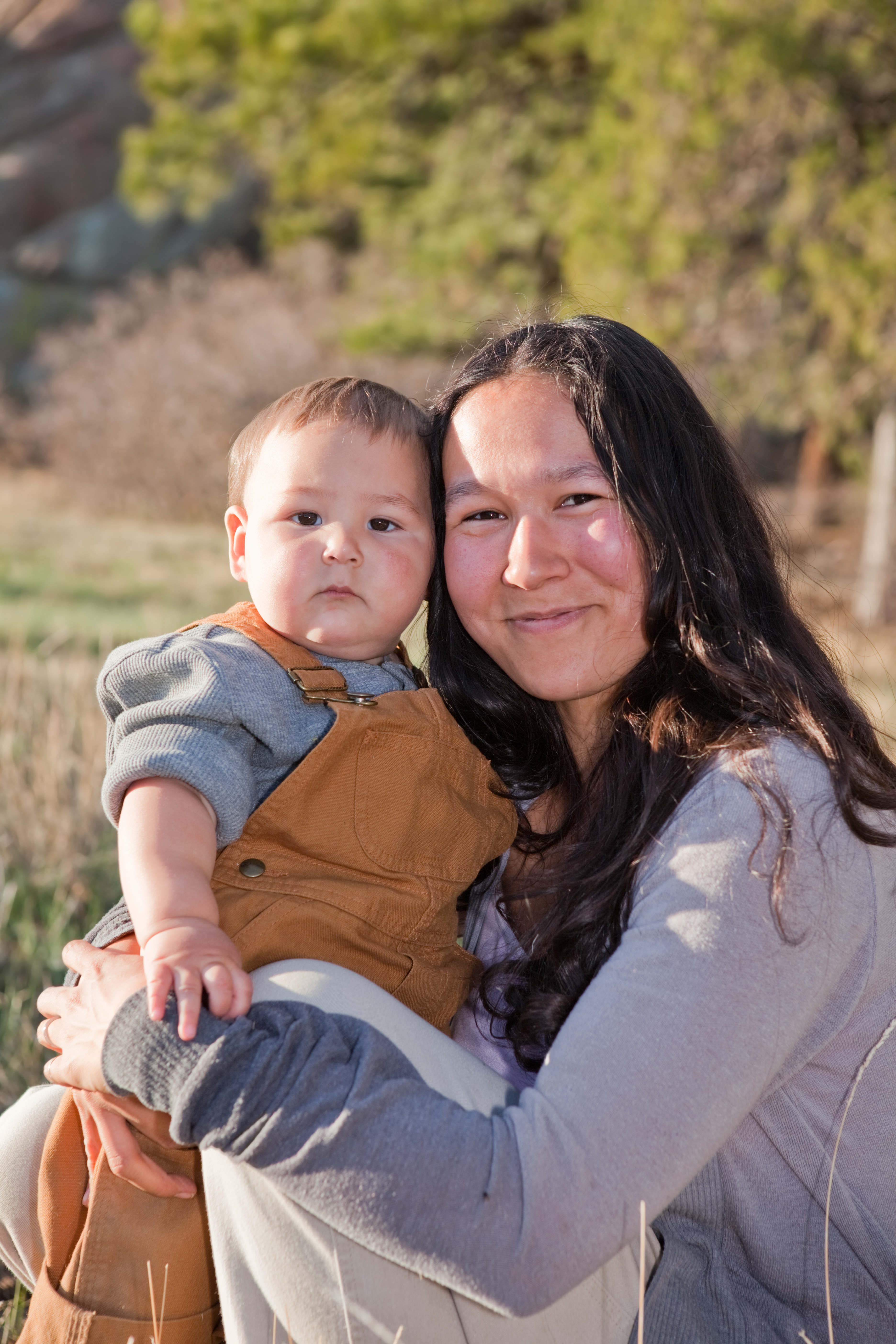 A Native American parent is laughing and smiling with their child