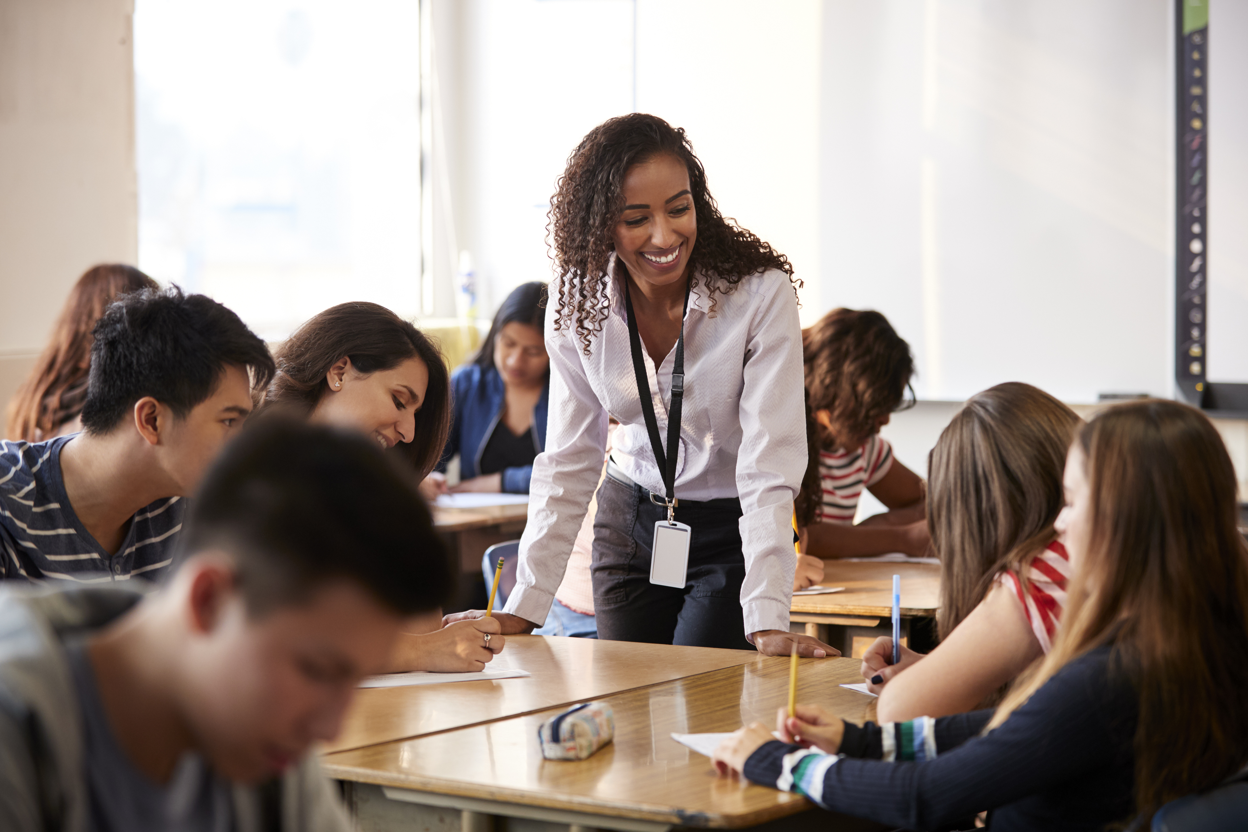 School administrator talking to students at lunch table