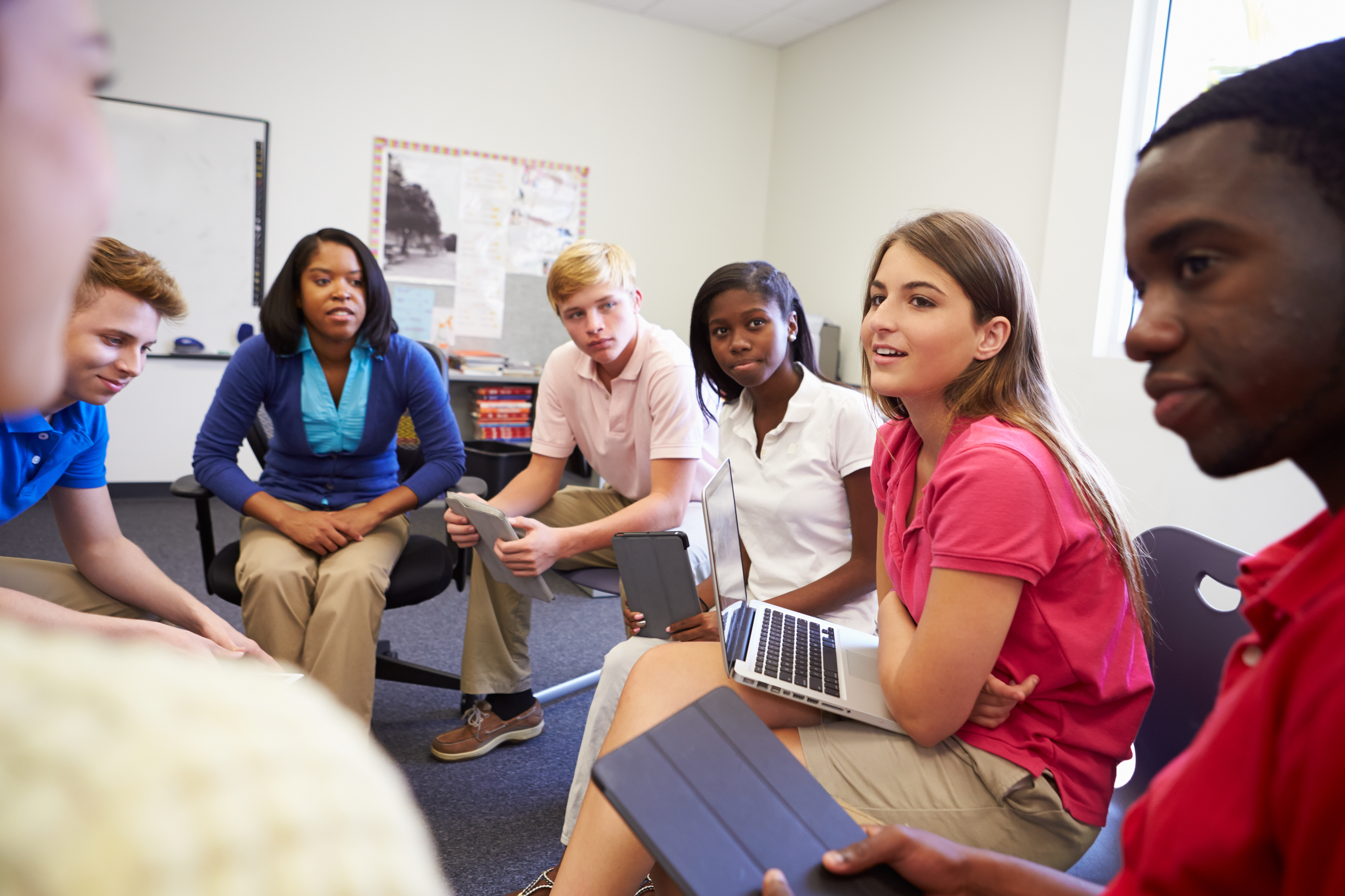 High school students and a teacher in a group discussion