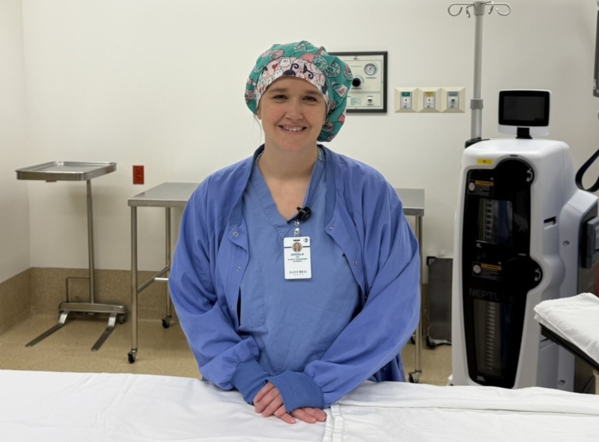 a woman wearing scrubs in a hospital room.