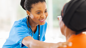 a health care provider puts her hand on a woman's shoulder