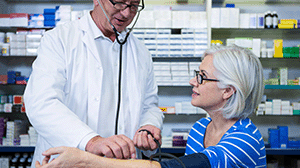 a woman gets her blood pressure checked in a pharmacy