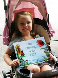 Young Girl in a stroller taking the book on the go